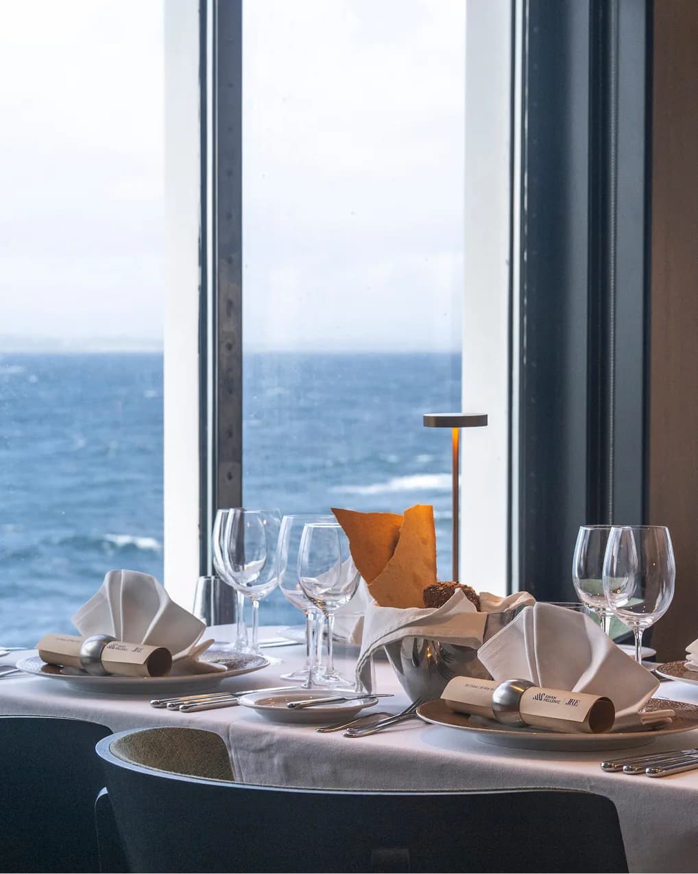 Dining table laid beside the panoramic windows of the restaurant