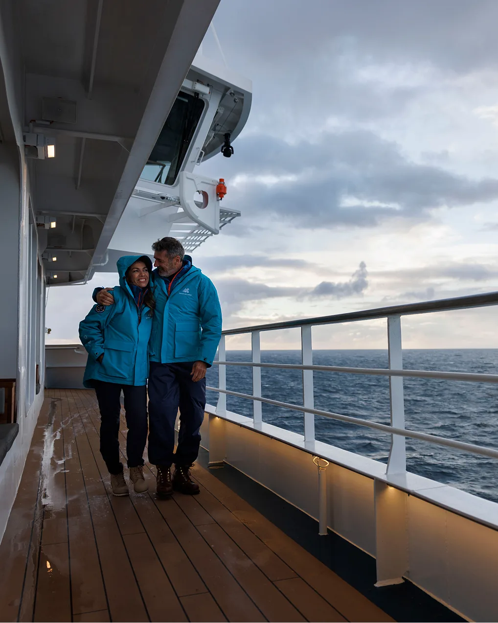 Couple walking the outer deck at dusk