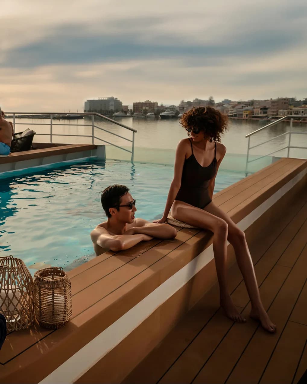 Guests relaxing by the pool deck at sunset