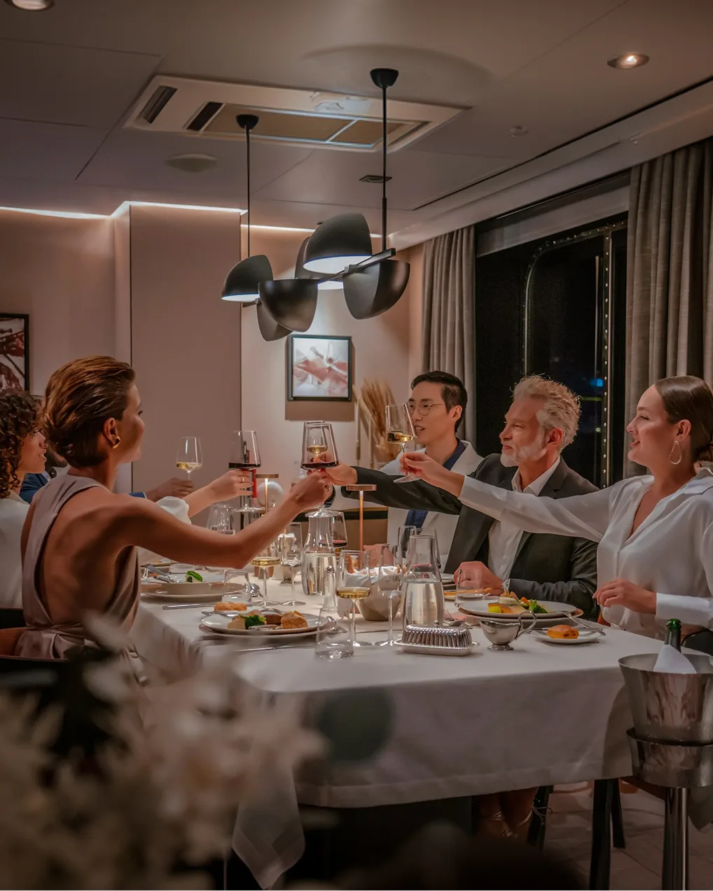 Guests raising a toast at dinner in the ship's restaurant