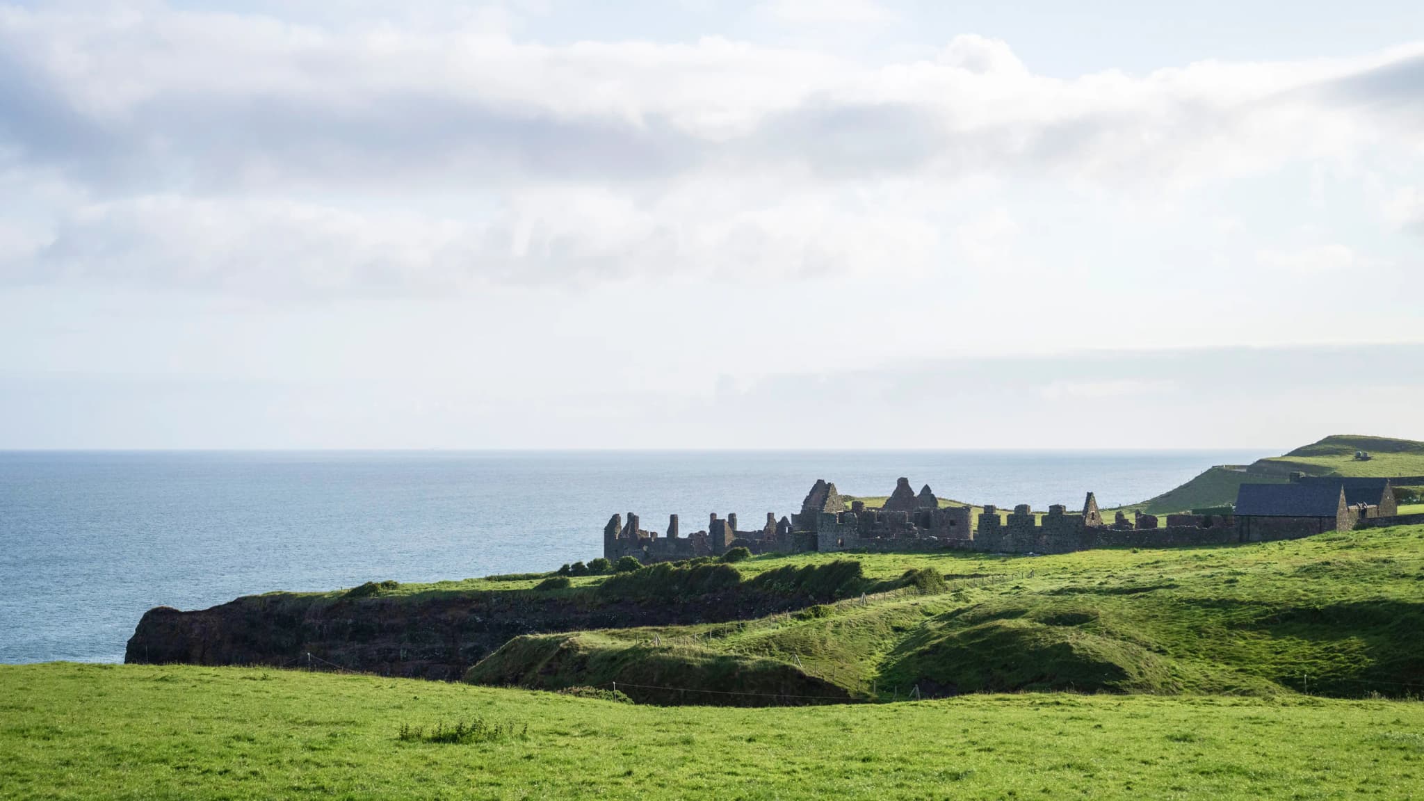 Clifftop castle ruins above the sea on a green headland