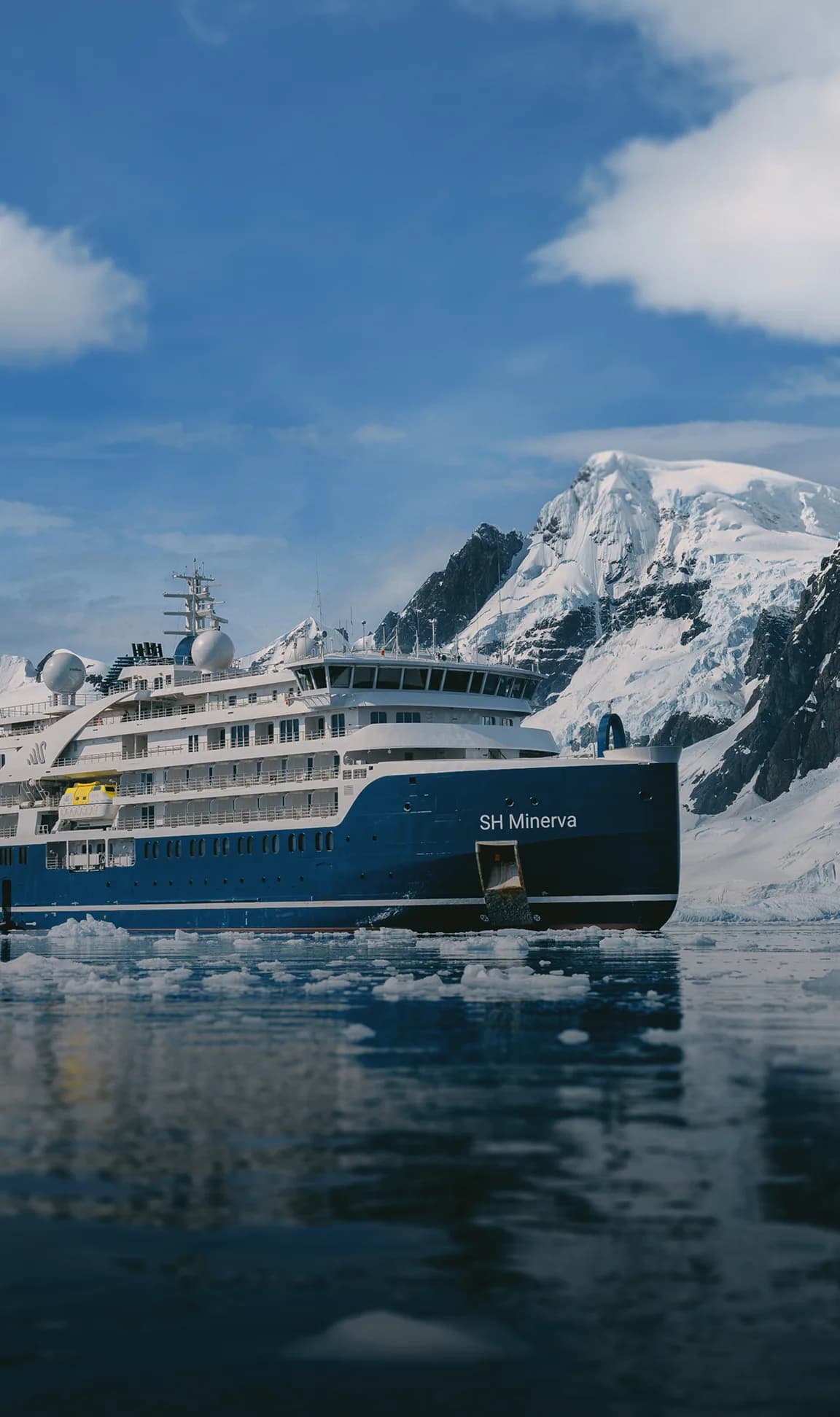 SH Minerva among ice floes beside a snow-covered peak