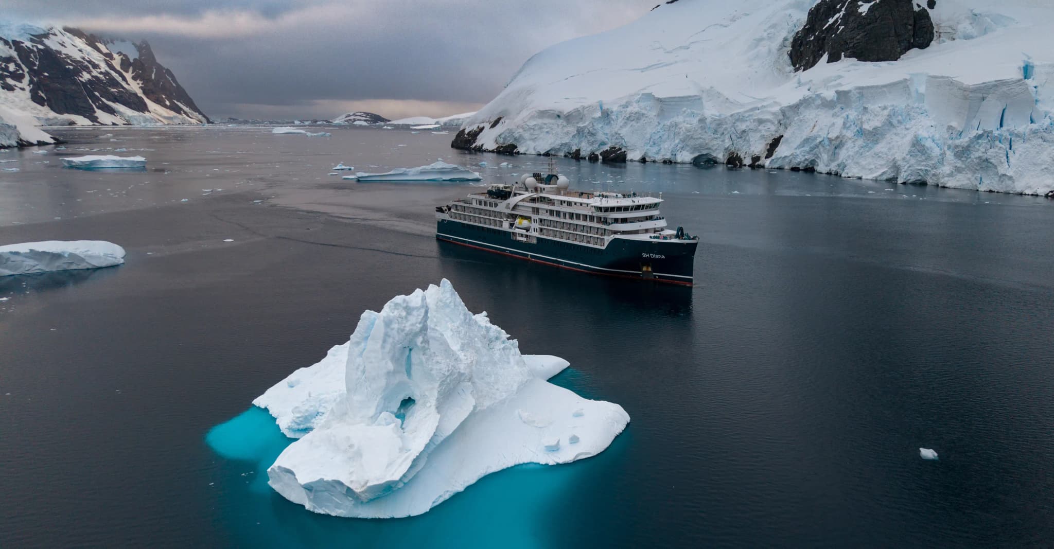 SH Diana sailing past an iceberg in Antarctica
